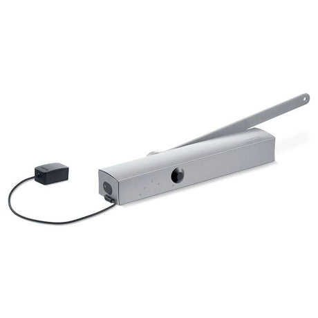 Der GEZE Türschließer TS 5000 E-Hy EN 3-6 mit Freilauffunktion, in Silber mit verlängertem Arm und schwarzem, kabelgebundenem Schaltkasten, steht auf weißem Grund - perfekt für Feuer- und Rauchschutztüren.
