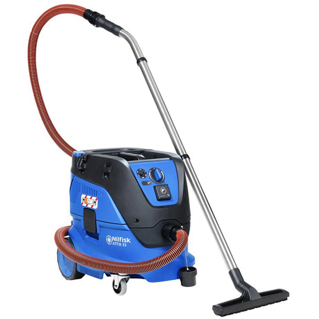 Der Nilfisk ATTIX 33-2M PC Sicherheitssauger M-Klasse (30 l, 1400 W), abgebildet in Blau und Schwarz mit silbernem Griff, rotem Schlauch und schwarzen Rädern, wird vor einem weißen Hintergrund gezeigt.