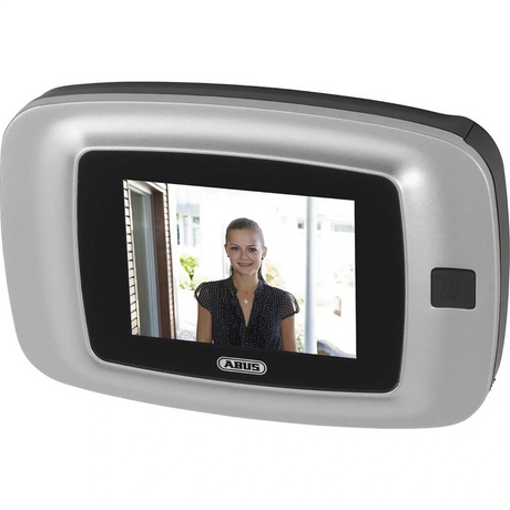 Der ABUS Digitaler Türspion DTS2814rec mit Aufzeichnungsfunktion zeigt auf seinem Display eine Frau vor der Tür. Es hat einen silbernen Rahmen, eine schwarze Taste auf der rechten Seite und das ABUS-Logo unter dem Display.