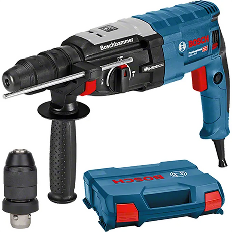 Ein blau-schwarzer Bosch Professional GBH 2-28 F Bohrhammer mit seitlichem Griff, zusätzlichem SDS-plus Bohrfutter und einem blauen Bosch-Koffer daneben.