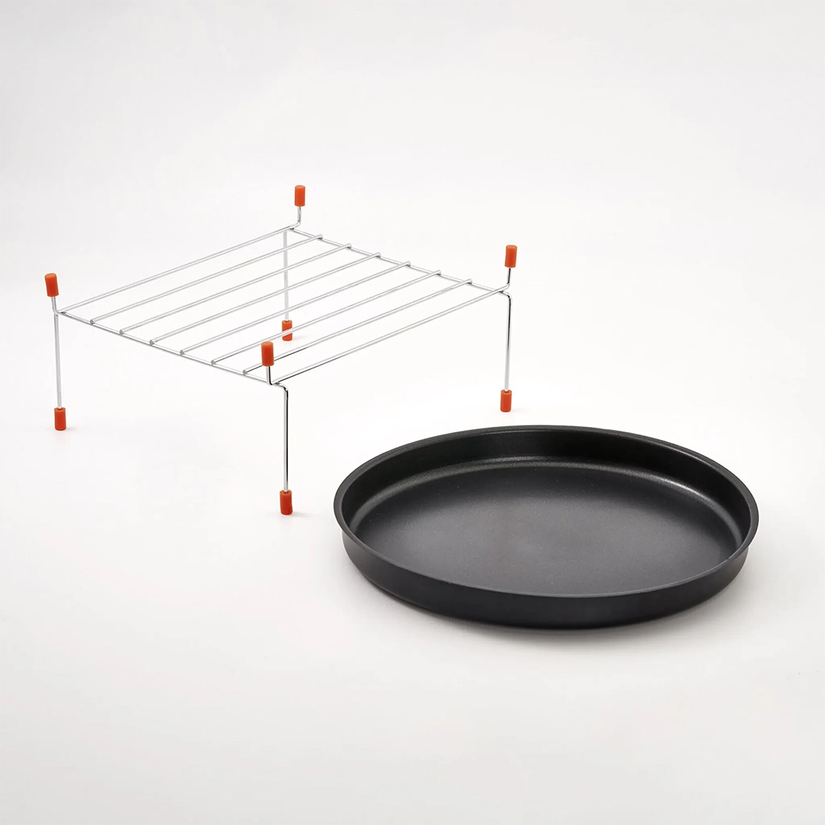 Ein schwarzes, rundes Backblech und ein Metallgitter mit orangefarbenen Füßen sind nebeneinander abgebildet, ideal für die CASO HCMG 25 Mikrowelle - silber von CASO, alles vor einem schlichten weißen Hintergrund.