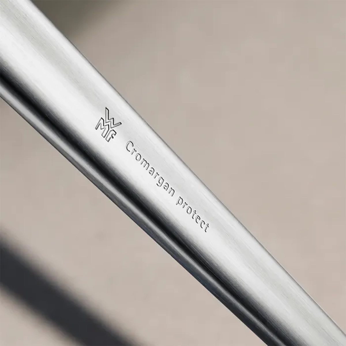 Nahaufnahme des Edelstahlgriffs vom WMF NEO Besteck-Set 30-tlg Edelstahl, mit eingraviertem WMF Logo und "Cromargan protect".
